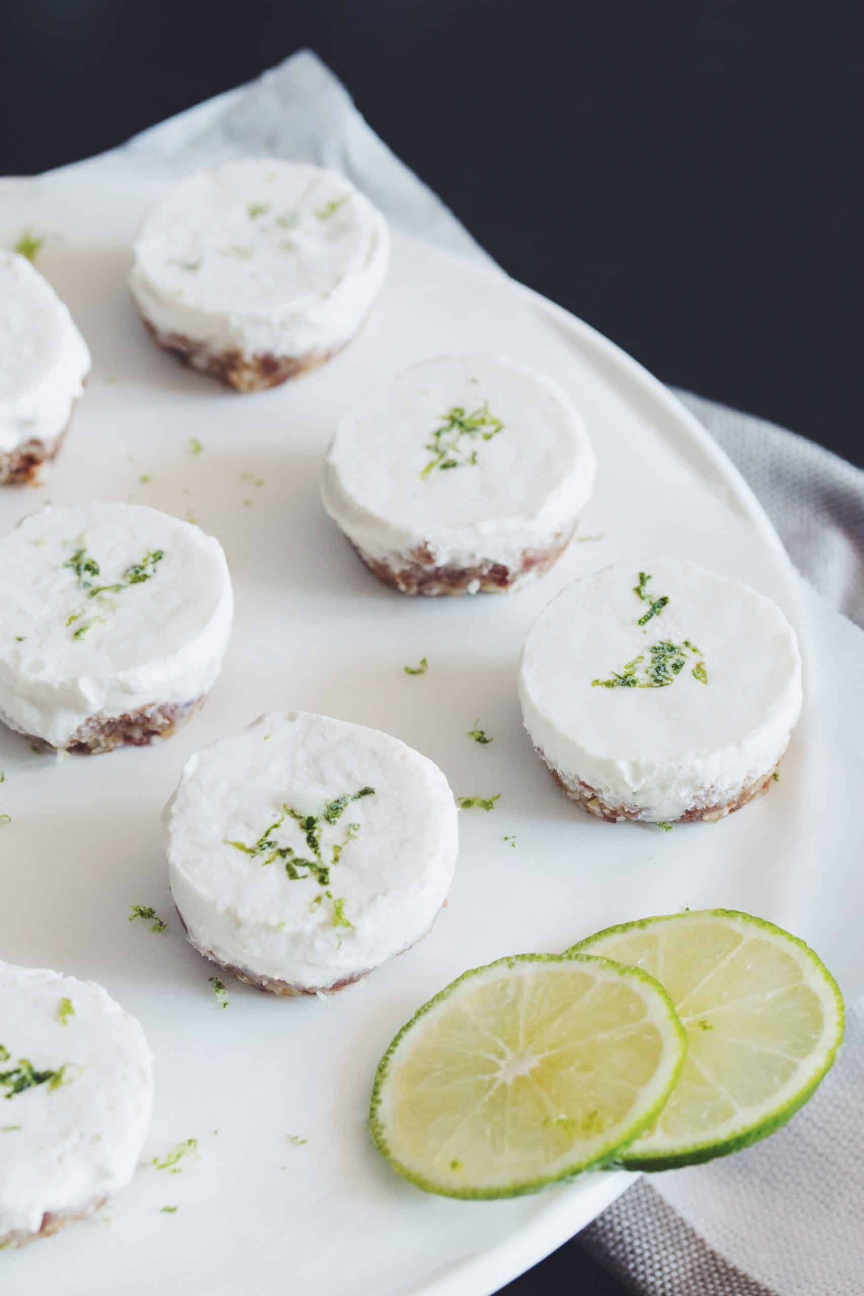 a plate of mini vegan cheesecake bites garnished with lime slices