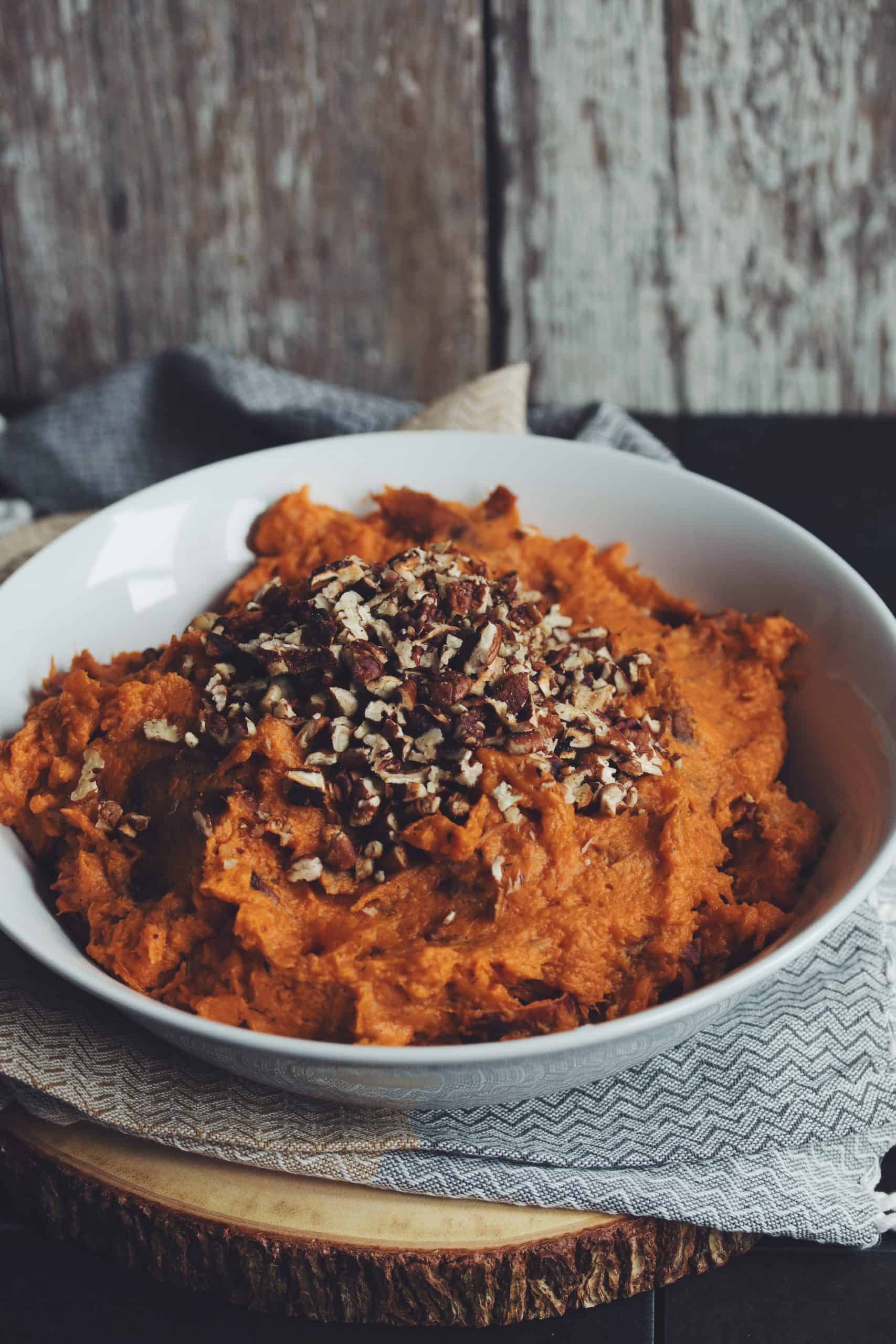 bowl of sweet potato mash with pecans on top