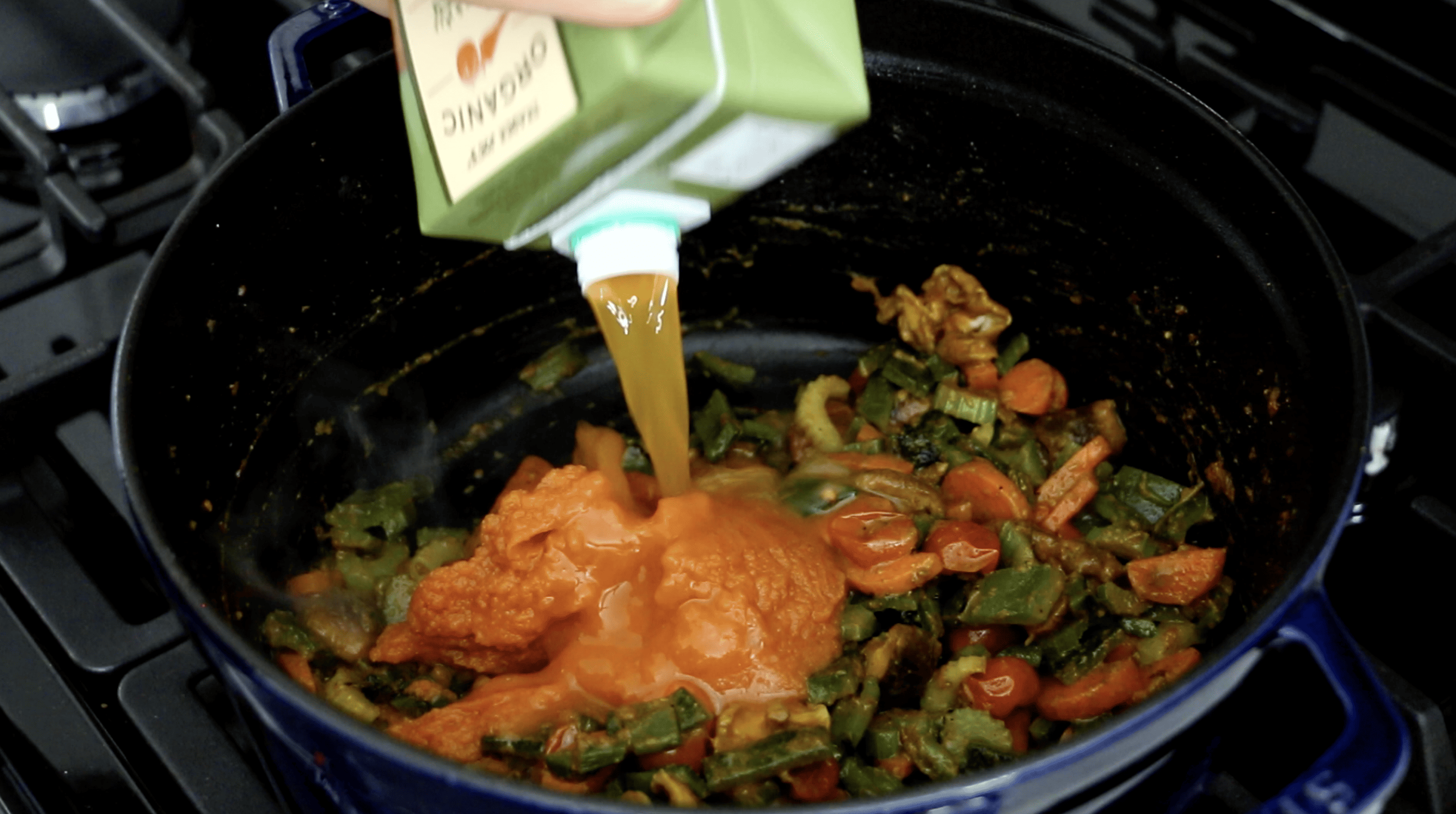 vegetable stock being added to the pot