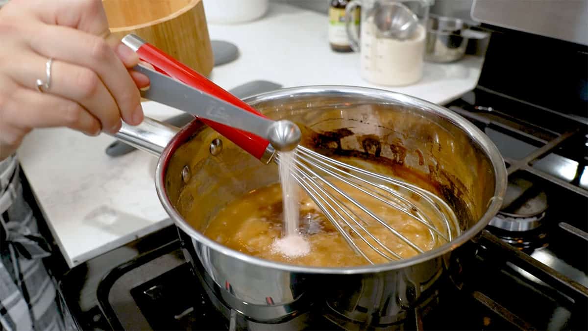 sauce pan with caramel in it and vanilla and salt being added
