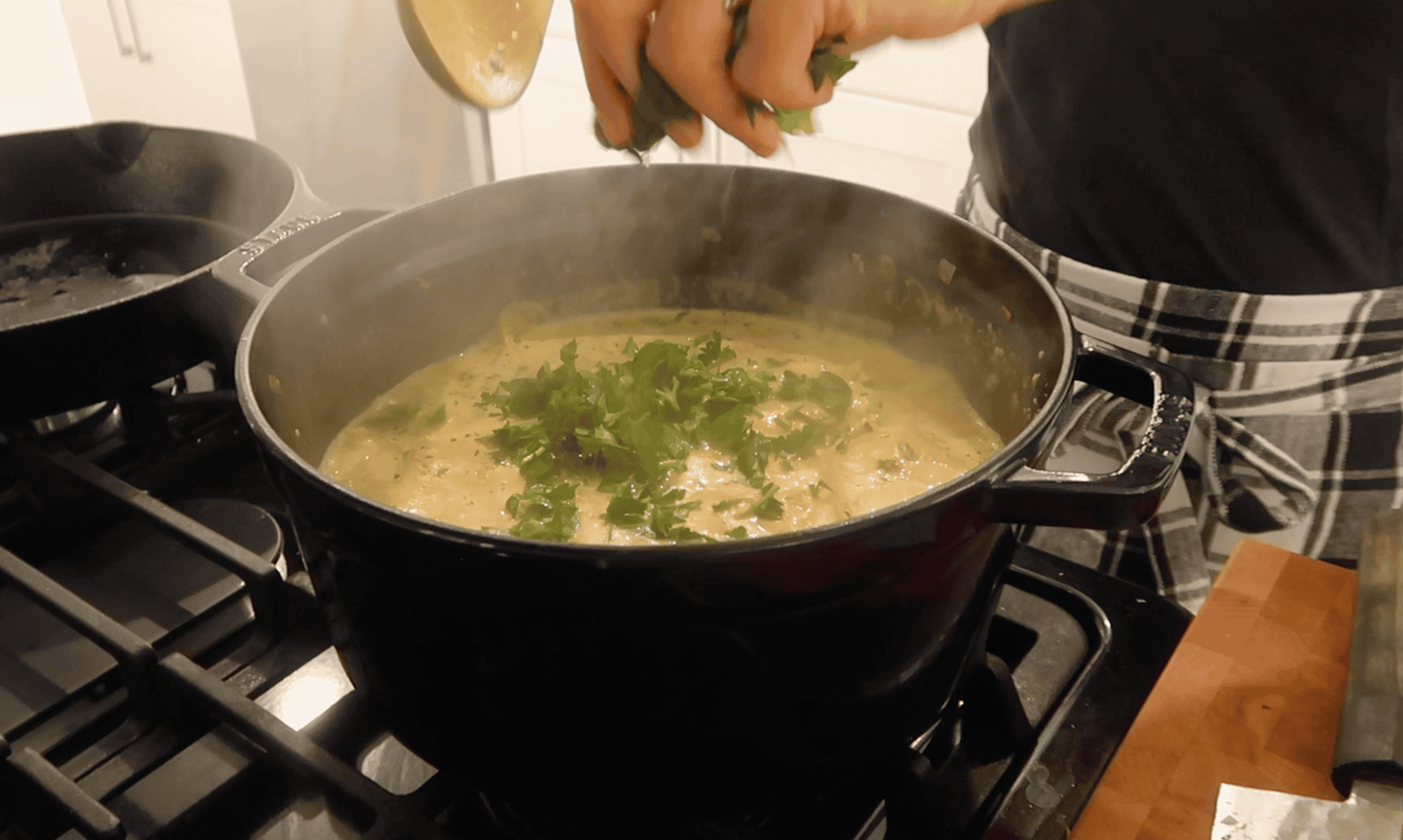 parsley being added to a pot of white lasagna soup