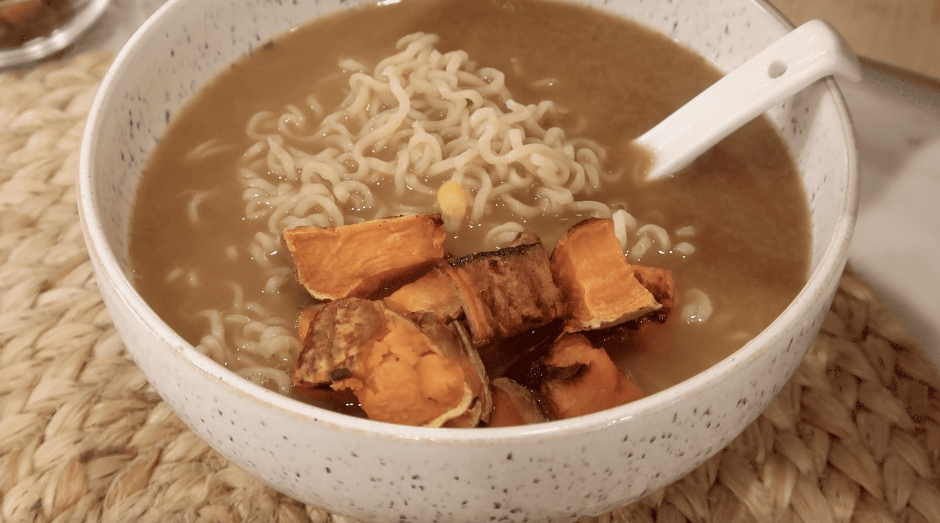 a bowl of ramen broth with noodles and sweet potato