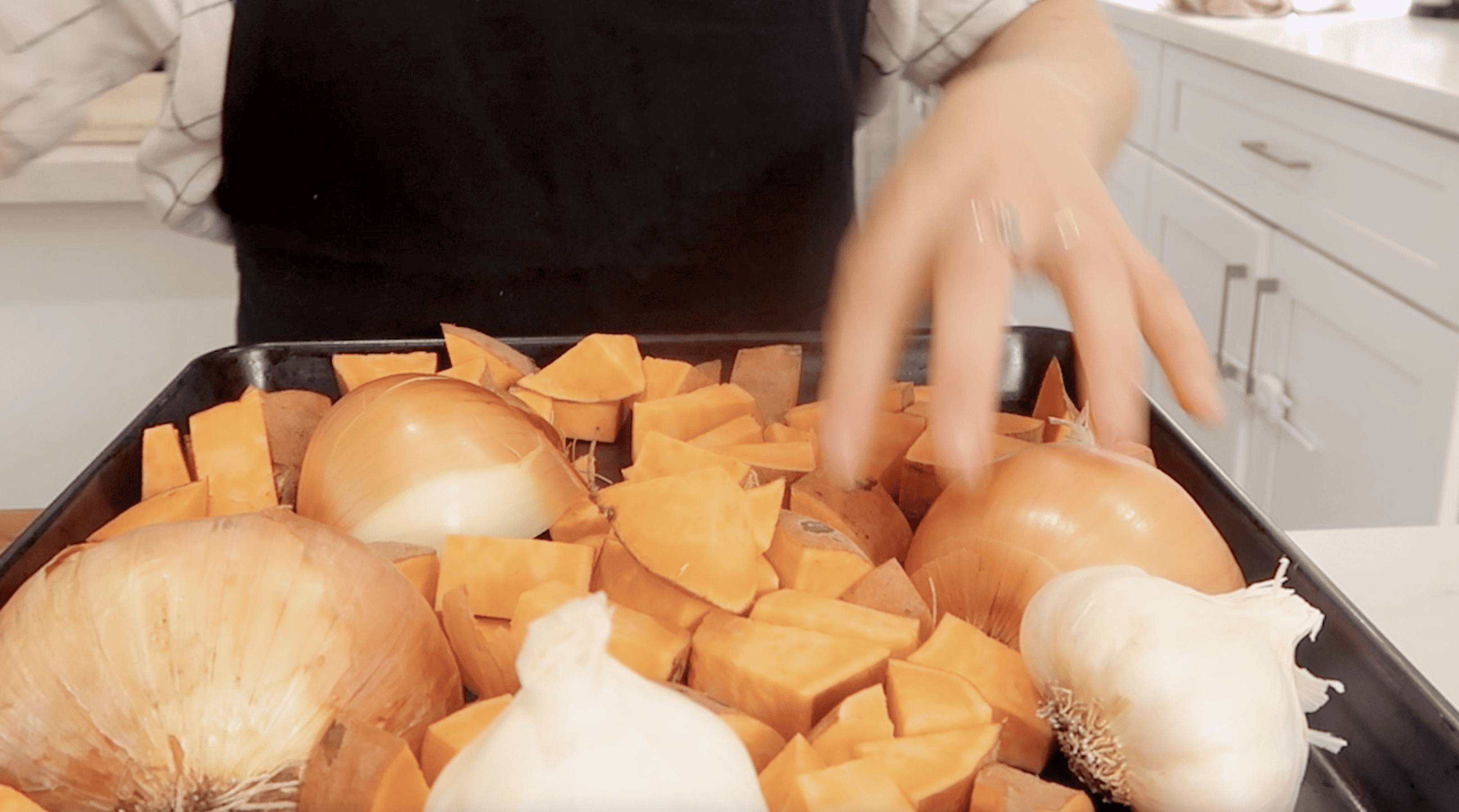 onion and sweet potato on a baking sheet