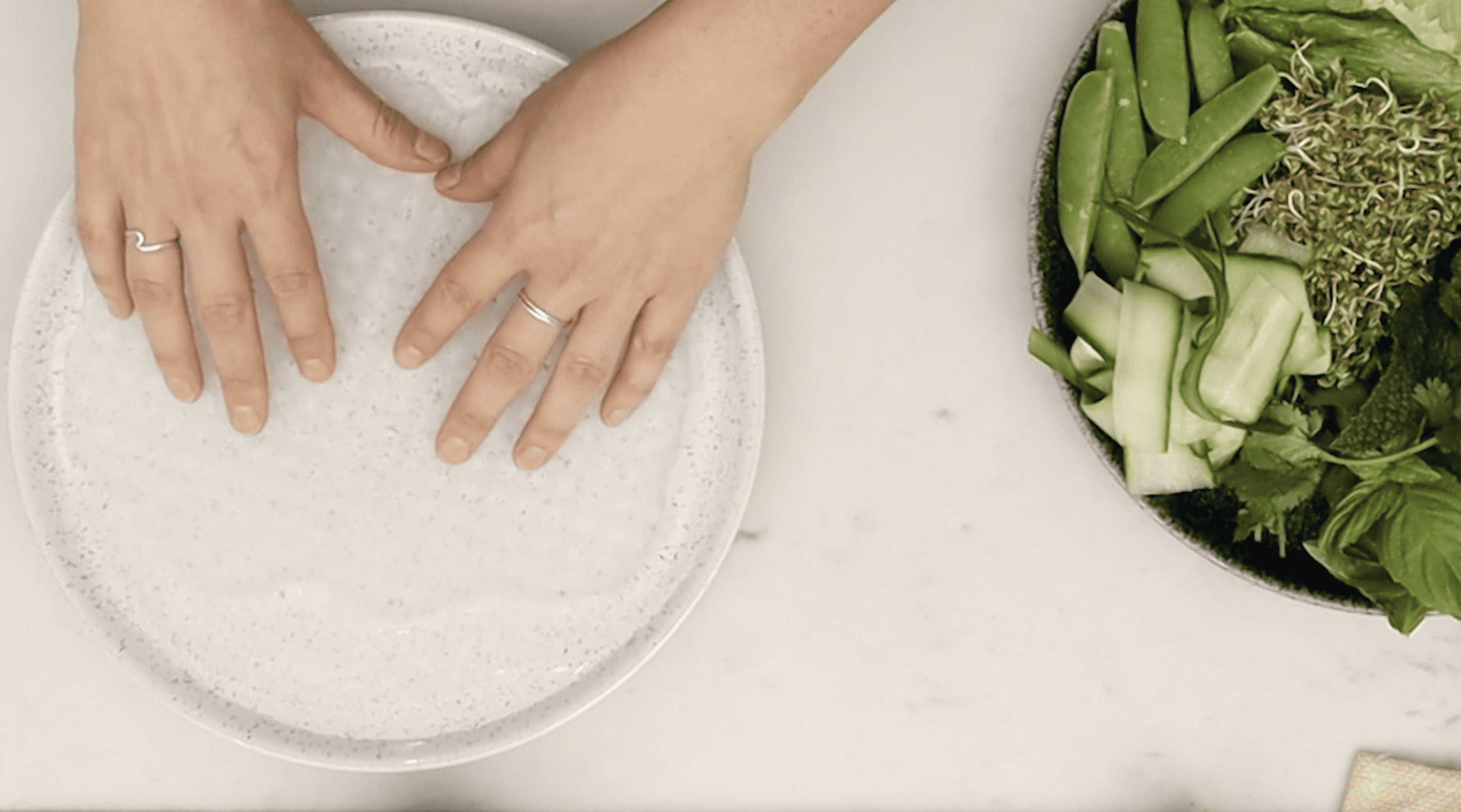 hands soaking a rice paper sheet
