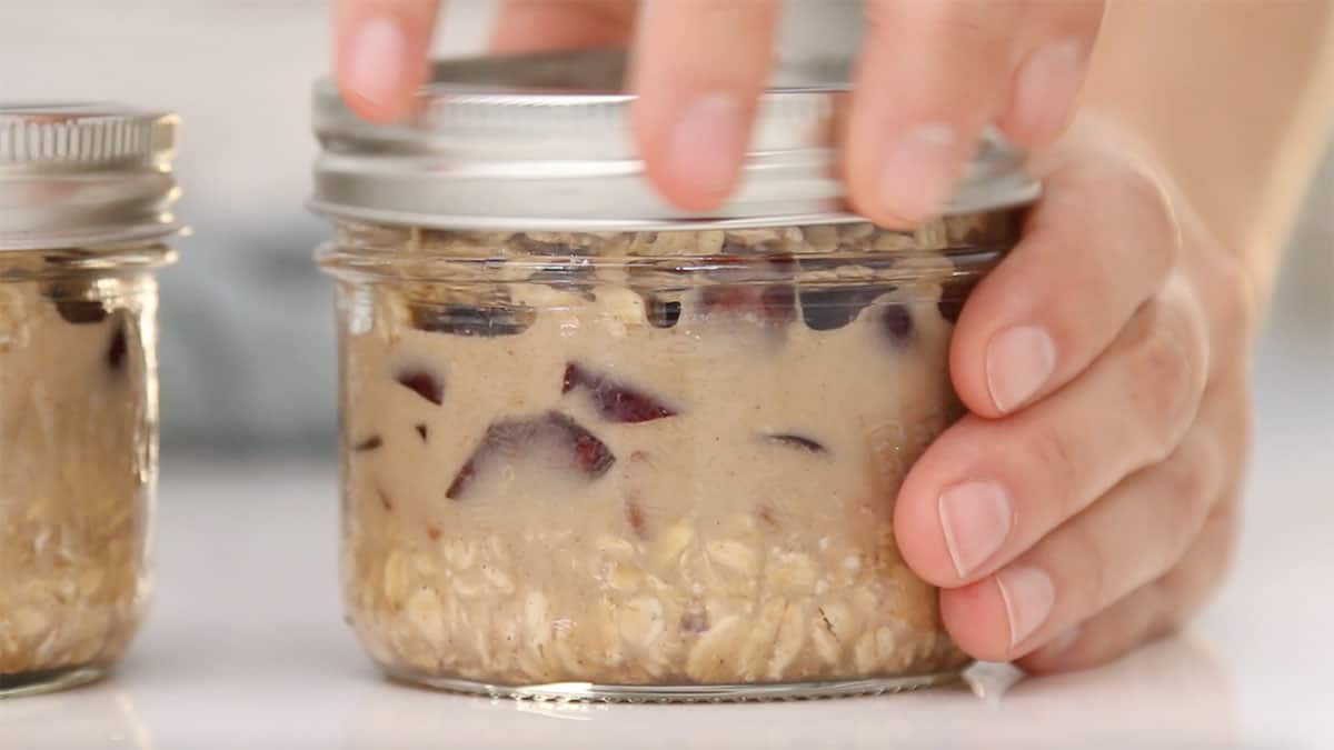 side angle of lid being put onto overnight oats jar