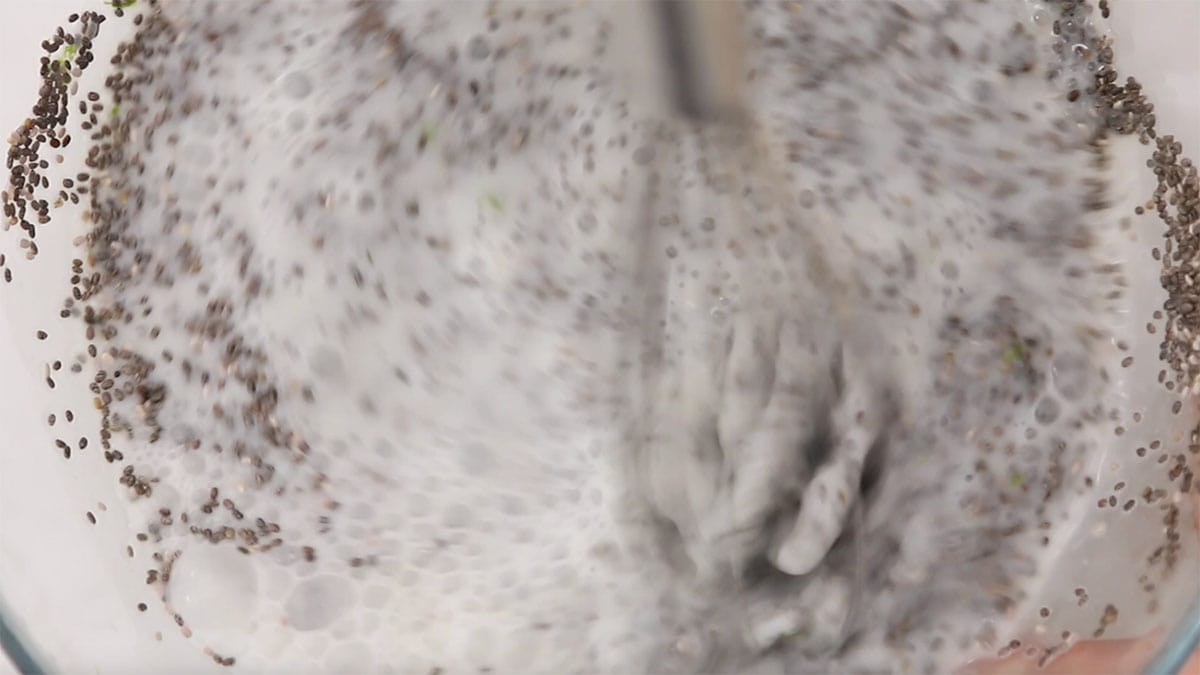 mixing bowl with chia seeds and milk being mixed together