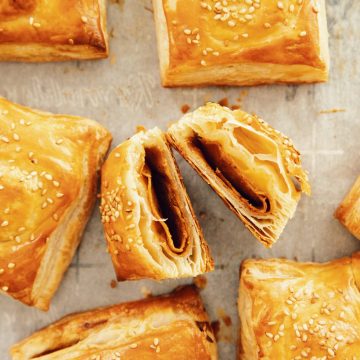 overhead with vegan ham and cheese croissants on a baking sheet with one open showing the inside