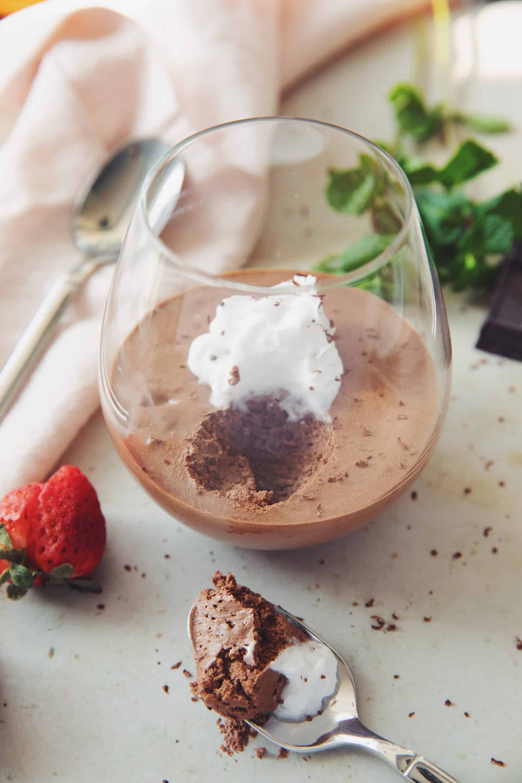 diners view of a serving of vegan chocolate mousse with a scoop take out