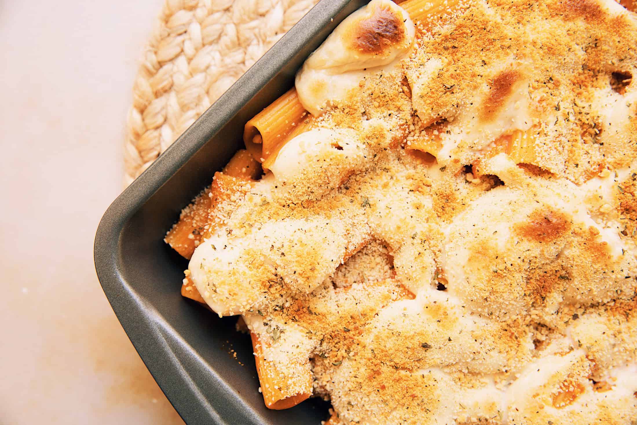 overhead of a baking dish with gochujang rigatoni baked with vegan mozzarella and breadcrumbs on top